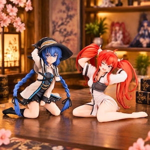 May include: Two anime-style figurines kneeling on a surface. The left figure has blue hair in long braids, a black witch hat, and a beige and black outfit. The right figure has long red hair in twin tails, a winking expression, and a white and black outfit.