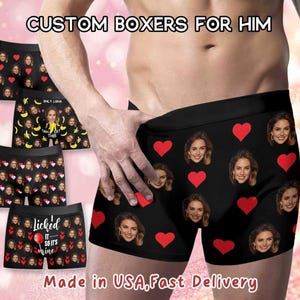 Puede incluir: Boxers negros con un patrón repetido de caras de mujer y corazones rojos. El texto "CUSTOM BOXERS FOR HIM" está en la parte superior. Otros pares presentan patrones de plátanos y caras, y el texto "Licked it so it's mine."
