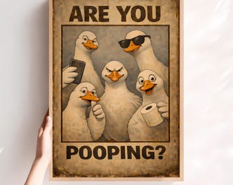 Op de afbeelding: Een ingelijste poster met een vintage uitstraling toont vijf cartoon ganzen met verschillende uitdrukkingen. Eén gans draagt een zonnebril, een andere houdt toiletpapier vast. De tekst bovenaan luidt "ARE YOU" en onderaan "POOPING?"