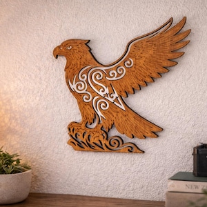May include: Wooden eagle wall art with detailed carving. The eagle is made of wood and has white decorative elements. It is mounted on a white wall. The wings are spread, and the eagle is perched on a decorative base. The artwork is suitable for interior decor.