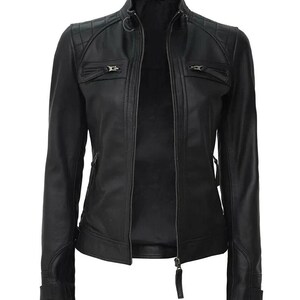 May include: A black leather jacket with a quilted shoulder design and a stand-up collar. The jacket features two zippered chest pockets, a full-length zipper closure, and zippered cuffs. The jacket is a classic style.