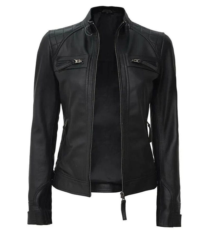 May include: A black leather jacket with a quilted shoulder design and a stand-up collar. The jacket features two zippered chest pockets, a full-length zipper closure, and zippered cuffs. The jacket is a classic style.