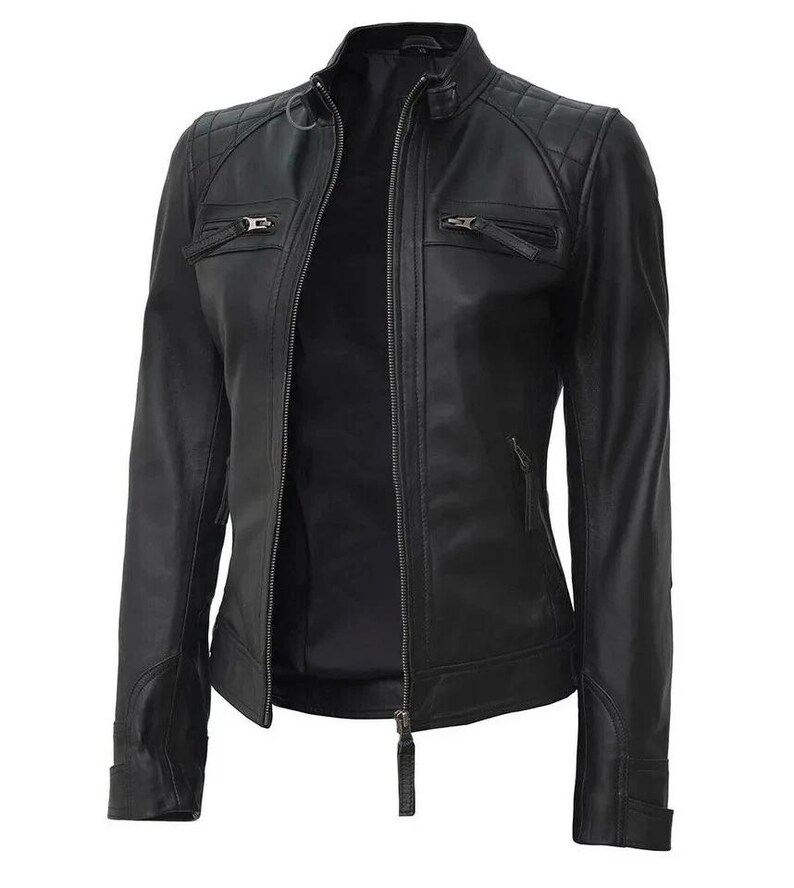 May include: A black leather jacket with a quilted shoulder design, a stand-up collar, and multiple zippered pockets. The jacket has a full-length zipper closure and a tailored fit. The sleeves have zippered cuffs. A classic outerwear piece.