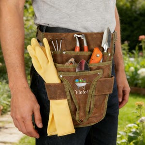 May include: A brown leather gardening tool belt with multiple pockets, holding various tools, including a trowel, clippers, and a small shovel. A pair of yellow gloves is tucked into a side pocket. The word "Violet" is printed on the front.