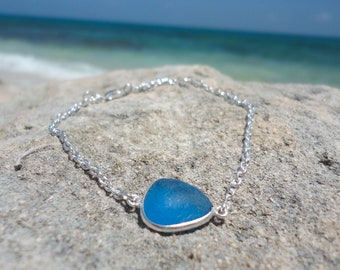 Può includere: Una collana a catena d'argento con un ciondolo in vetro blu. Il ciondolo ha la forma di una lacrima e ha una superficie liscia e lucida.
