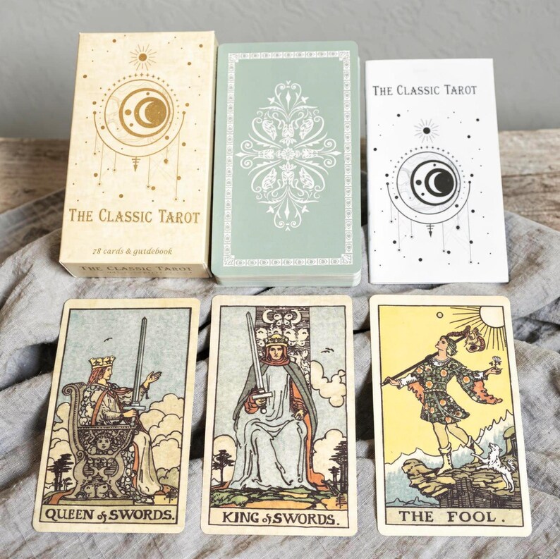 Rider Waite tarot cards Queen of Swords, King of Swords and The Fool displayed with Classic Tarot box and guidebook