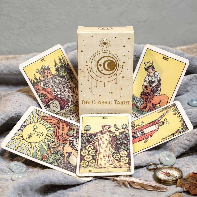 Classic Rider Waite tarot deck display featuring Empress, Strength, Sun and Nine of Pentacles cards with decorative tarot box
