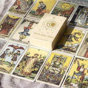 Classic Tarot deck box placed on full Rider Waite tarot card spread featuring Major Arcana cards