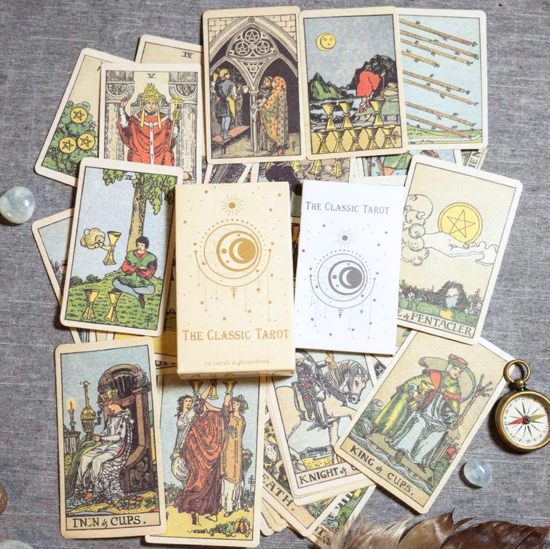 Complete Rider Waite tarot deck spread with Classic Tarot box, English guidebook and traditional tarot illustrations on cloth background