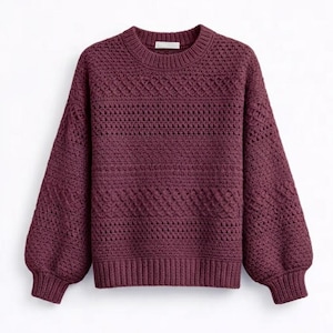 May include: A burgundy-colored sweater with a crew neck and long, voluminous sleeves. The knitwear features a textured pattern across the chest and sleeves, with ribbed cuffs and hem. The sweater is a solid color and appears to be made of a soft material.