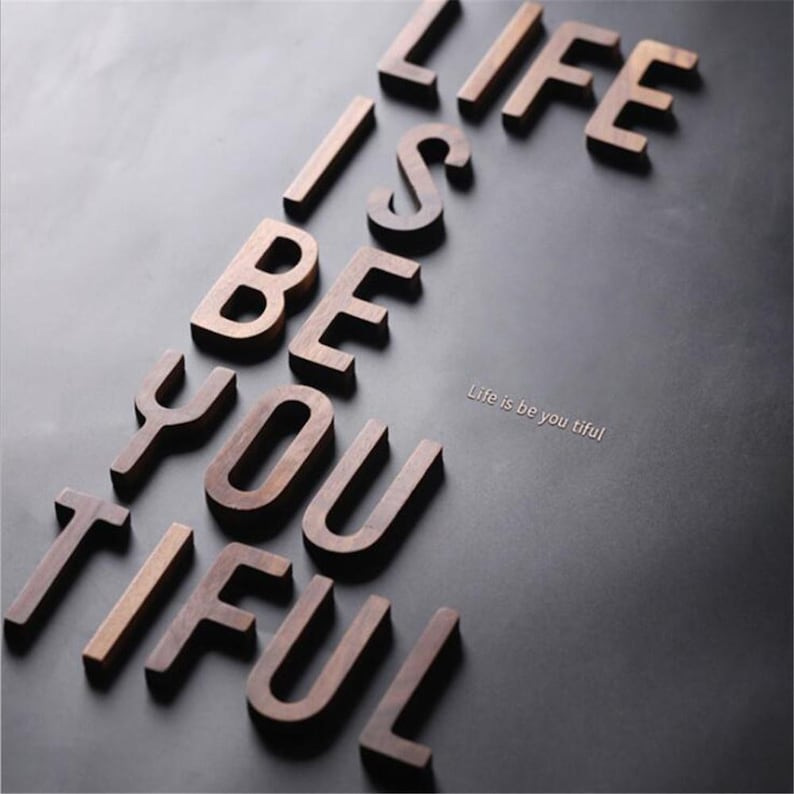 May include: A white ceramic mug with a black handle and the text "But First, Coffee" in a bold, black font. The mug is set against a blurred background, suggesting a cozy setting.