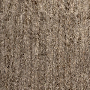 May include: Close-up of a woven rug with a natural, earthy aesthetic. The rug features a textured surface with a repeating pattern of vertical braids in varying shades of brown and tan. This rug is suitable for home decor.