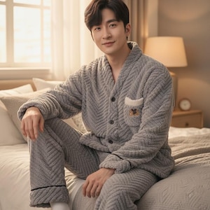 以下が含まれることがあります： ヘリンボーン柄のグレーのぬいぐるみパジャマセット。ボタン付きのトップスとポケット、お揃いのパンツが含まれています。パジャマは柔らかく、質感のある素材で作られており、くつろぐのに最適です。快適さを追求したセットです。