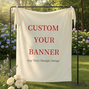May include: Cream-colored banner with the text "CUSTOM YOUR BANNER" in red, displayed on a black metal stand. The banner also states "Any Text/ Design/ Image". The scene is outdoors with flowers and greenery.