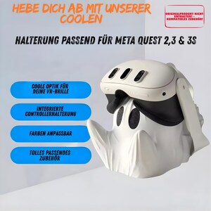 Könnte beinhalten: Ein weißer, geisterförmiger Ständer für ein VR-Headset mit glattem, skulpturalem Design und zwei dunklen, augenähnlichen Öffnungen. Der Ständer hält ein weiß-schwarzes VR-Headset. Text auf dem Bild: HEBE DICH AB MIT UNSERER COOLEN HALTERUNG PASSEND FÜR META QUEST 2,3 & 3S.