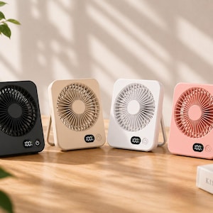 May include: Four portable square desk fans in black, beige, white, and pink. Each fan features a circular grille, a digital display showing 100, and a power button on the lower front. The fans have a foldable stand on the back for upright positioning.