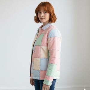 May include: A pastel patchwork jacket in pink, blue, green, and cream. The jacket has a light blue collar and cuffs, with visible stitching. The jacket is buttoned up and worn with blue jeans.