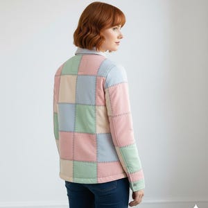 May include: A pastel patchwork jacket in pink, blue, green, and beige squares. The jacket has a button closure and a collar. The stitching is visible, adding to the handcrafted aesthetic. The jacket is worn with blue jeans.