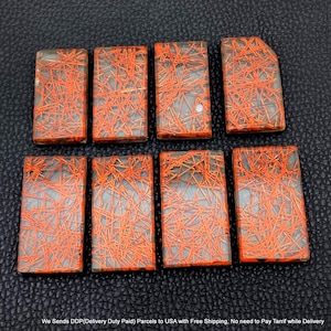 May include: Eight rectangular cabochons featuring a translucent, pale grey base embedded with a dense network of thin, intersecting orange needle-like inclusions. Each piece has a smooth, flat surface and distinct, sharp edges arranged in two rows.
