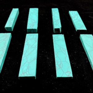 May include: Eight rectangular pieces of turquoise-coloured material with a dark brown webbed matrix pattern. The pieces are arranged in two rows, each featuring a flat surface and straight edges, displaying a consistent cyan hue throughout.
