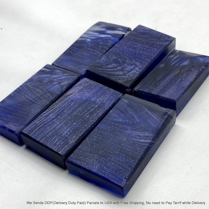 May include: A set of five rectangular blocks made of dark blue resin with a swirling, pearlescent finish. Each block features a smooth, polished surface with deep indigo and navy tones, arranged in a staggered formation on a white surface.