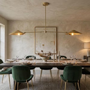Könnte beinhalten: Ein Esszimmer mit einem dunklen Holztisch und grünen Samtstühlen. Über dem Tisch hängt eine goldfarbene Leuchte. Der Raum ist mit einem abstrakten Gemälde dekoriert und wird von natürlichem Licht erhellt.