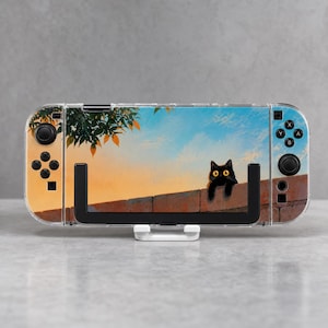 May include: A handheld gaming console featuring a custom skin with a black cat perched on a brick wall against a sunset sky with orange tree leaves. The device includes black joysticks, directional buttons, and action buttons on both sides.