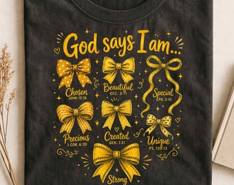 May include: A black crew neck t-shirt featuring yellow graphic text that reads God says I am followed by six yellow bows with labels: Chosen, Beautiful, Special, Precious, Created, Unique, and Strong, each paired with a Bible verse reference.