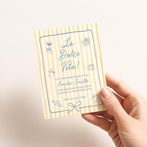Puede incluir: Una tarjeta de invitaci&oacute;n rectangular con un fondo de rayas verticales de color amarillo p&aacute;lido y blanco con un borde azul. El texto dice La Dolce Vita! Let's shower bride-to-be Amelia Smith Saturday May 10th at 2pm 123 Main St Anywhere 12345 RSVP 123-456-7890.