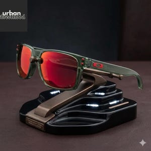 May include: Green-framed sunglasses with red lenses on a black and bronze stand. The sunglasses are rectangular and labelled "TRANSLUCENT TITAN - PREMIUM COLLECTION". The "urban street hood" logo is in the upper left corner.