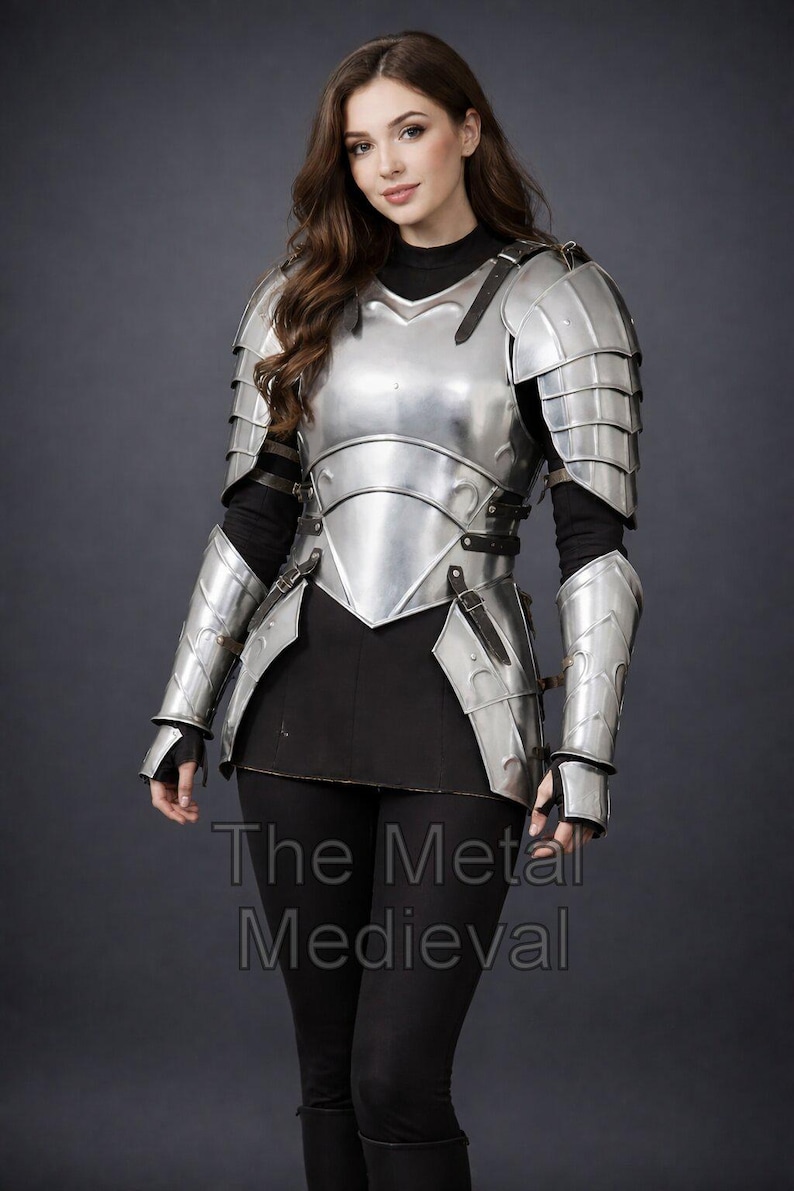 May include: A polished silver medieval armor set, including a breastplate, shoulder guards, and arm protection. The armor is worn over a black top and leggings. The Metal Medieval is printed at the bottom.