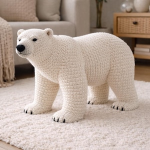 May include: A handcrafted, off-white crochet polar bear sculpture. The bear has a black nose and eyes, with black claws on its feet. The bear is standing on a cream-colored rug, and is a decorative item.