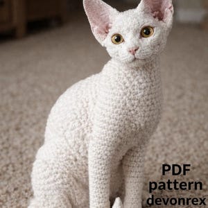 May include: A crocheted white cat with large ears and yellow eyes sits on a patterned carpet. The cat is made of a textured yarn, and the image includes the text "PDF pattern devonrex".