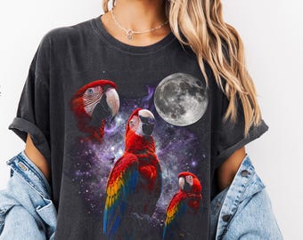 月に向かって吠えるコンゴウインコ。ヴィンテージ風オウムのグラフィックTシャツ。動物好きへのギフト。オーバーサイズ ストリートウェア 夜空。星柄 ユニセックス 90年代 Y2K Tシャツ