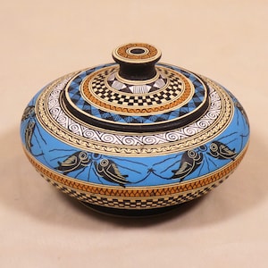May include: A hand-painted ceramic bowl with a lid. The bowl has a light blue background with black and white fish designs. The lid has a black knob and is decorated with geometric patterns in black, white, and brown.