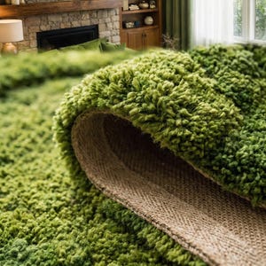 May include: Close-up of a rolled-up, shaggy green rug with a textured, plush surface. The underside reveals a tan, woven backing. The rug is in a living room setting, with a fireplace and furniture visible in the background.