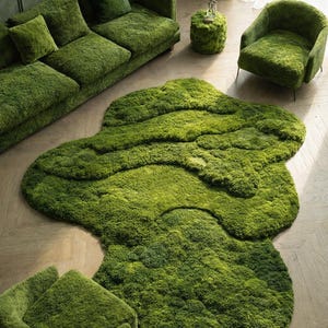 May include: A green moss-covered living room set, including a sofa with pillows, an armchair, a small round table, and a unique rug. The rug has an organic shape. The furniture is a vibrant green color, creating a natural, earthy aesthetic.