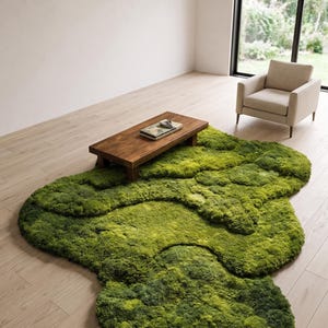 May include: A unique, green, moss-like rug with an organic shape dominates the room. A low, rectangular wooden coffee table sits atop the rug. A neutral-toned armchair and a large window with a view complete the scene.