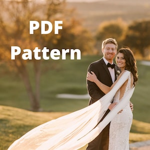 Può includere: Una coppia posa per una foto di matrimonio. La sposa indossa un abito bianco con un lungo velo che fluttua nel vento. Lo sposo indossa un abito nero e un papillon nero. La coppia è in piedi su un sentiero in un campo erboso. Il testo "PDF Pattern" è sovrapposto all'immagine.