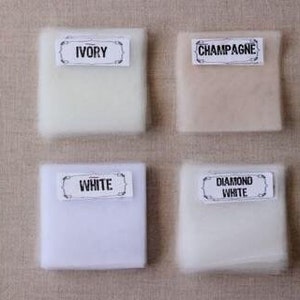 May include: Four fabric swatches labeled with different shades of white: Ivory, Champagne, White, and Diamond White.