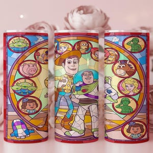 Puede incluir: Tres vasos de acero inoxidable con un dise&ntilde;o de vidriera que presenta personajes de la pel&iacute;cula de animaci&oacute;n Toy Story. El dise&ntilde;o incluye a Woody, Buzz Lightyear y otros personajes en un estilo de dibujos animados colorido. Los vasos tienen un borde rojo.
