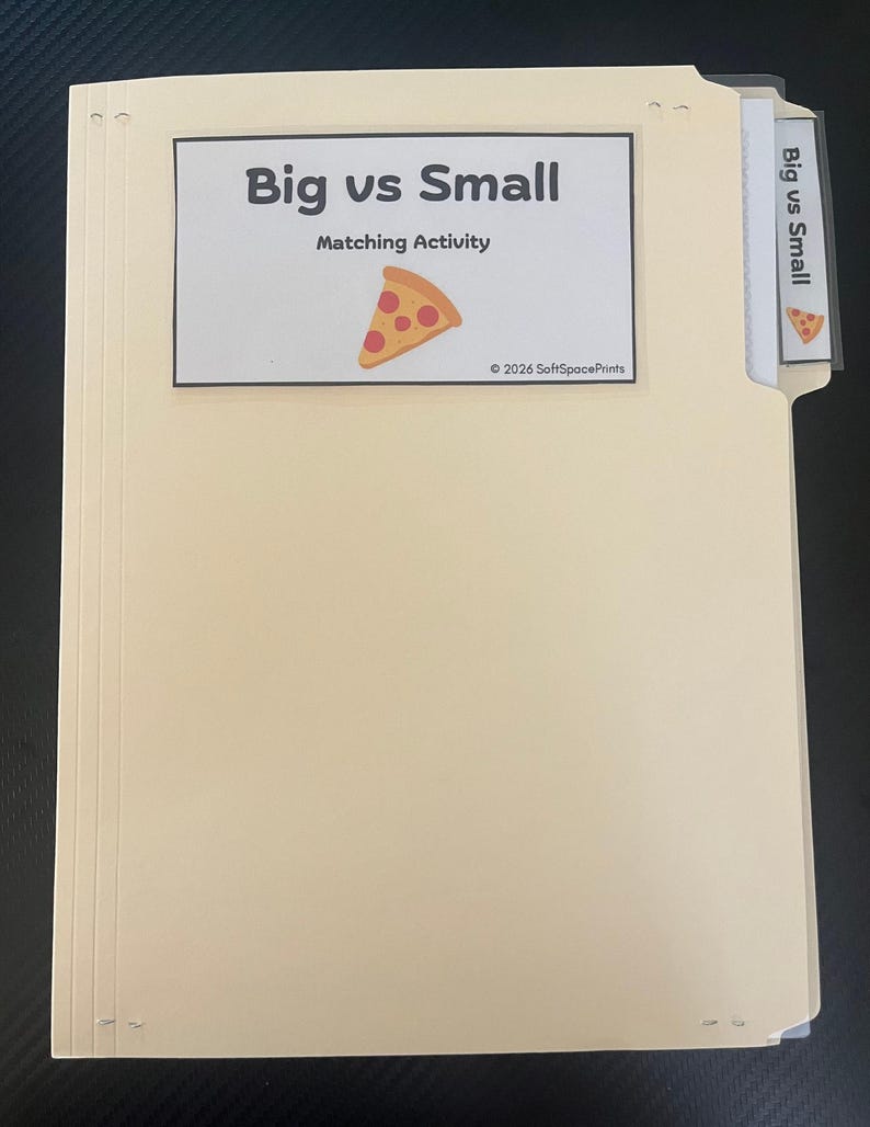 May include: A light beige file folder containing a matching activity. The front label reads Big vs Small Matching Activity with a pizza slice graphic and 2026 SoftSpacePrints text. A matching tab label is visible on the right side.