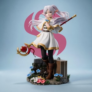 May include: A detailed figurine of a female anime character with long white hair, wearing a white dress with gold trim, black tights, and brown boots. She holds a staff and a flower, standing on a stone base with flowers and a suitcase.