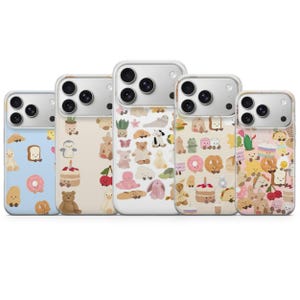 May include: Five phone cases with different colourful patterns. Designs include cartoon bears, food items like bread and doughnuts, and other cute illustrations. The cases have a clear border and a camera cutout.
