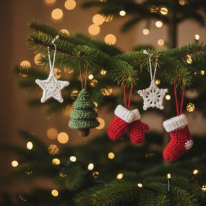 May include: A collection of five crocheted Christmas ornaments hanging from a pine tree branch. The set includes two white stars, one green pine tree, a pair of red mittens with white cuffs, and a single red stocking with a white cuff.