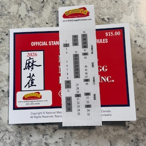 May include: A rectangular white card with a red border and blue trim featuring the text 2026 and Chinese characters. A vertical white strip with a numbered list from 1 to 55 and categories like Odds, Evens, and No Jokers is placed over the card.