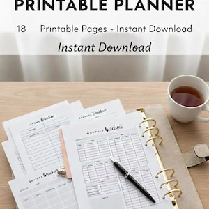 Op de afbeelding: Een financieel printbaar planner met 18 printbare pagina's wordt gepresenteerd op een houten oppervlak. De planner bevat pagina's voor inkomsten, uitgaven en maandelijkse budgetten. Een pen en een kopje thee zijn ook aanwezig.