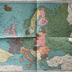 Peut inclure: Carte vintage de l'Europe, avec les pays représentés en différentes couleurs sur un fond bleu clair. La carte comprend du texte indiquant l'éditeur et le lieu. La carte est pliée, montrant des plis.