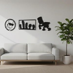 May include: A modern living room scene featuring a light gray sofa with wooden legs, three black wall art pieces, and a potted plant. The room has a neutral color palette with natural light.