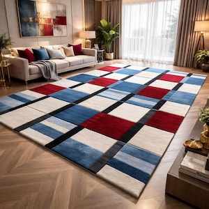 May include: A large rectangular area rug with a geometric pattern. The rug features squares of red, blue, white, and black. The rug is placed on a hardwood floor in a living room setting.